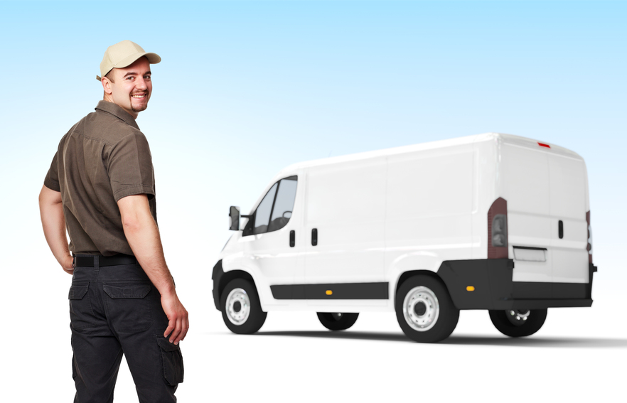 Smiling worker with cap and white truck